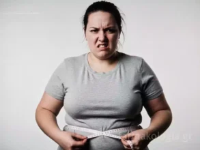 Μια γυναίκα μετρά τη μέση της, αποτυπώνοντας την πρόκληση της απώλειας κιλών με δίαιτες.